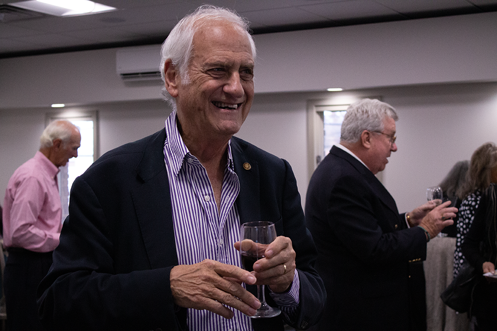 Arthur Meisel smiling and holding glass of red wine